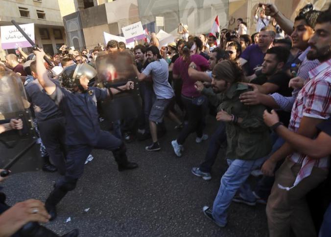 A Lebanese security officer aims at protesters in Beirut on 20 June 2013. (Photo: Al-Akhbar - Haitham Moussawi)